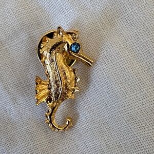 Gold Seahorse brooch with sapphire eye. Comes with sheer gift pouch!